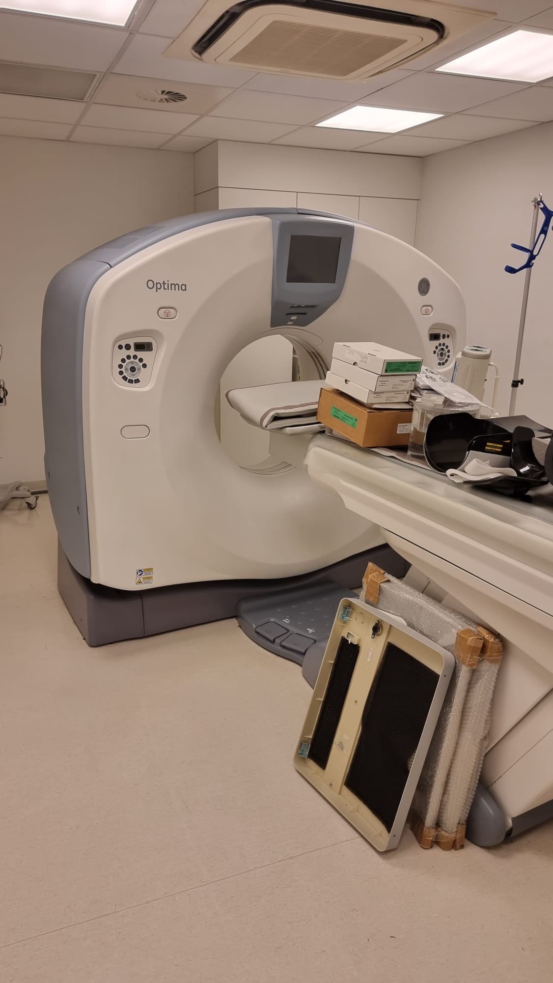 GE Optima CT660 / Optima 660 128-slice CT scanner for sale — front three-quarter view of Optima gantry and patient table inside clinical CT suite in Miami, Florida